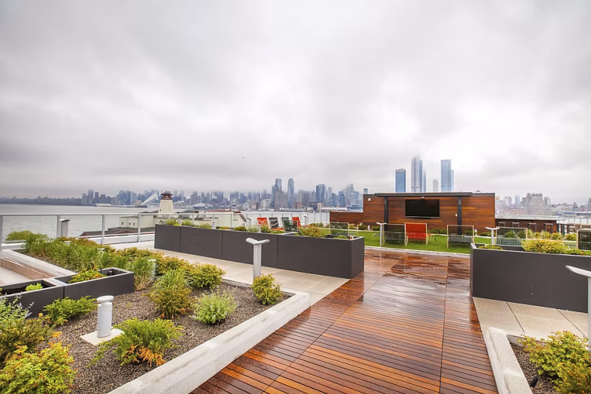 Rooftop garden featuring a wooden deck with a city skyline view at Harbor 1500 Apartments