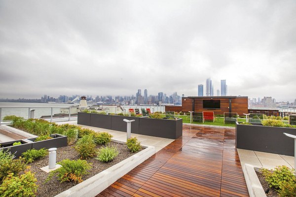 Rooftop garden featuring a wooden deck with a city skyline view at Harbor 1500 Apartments