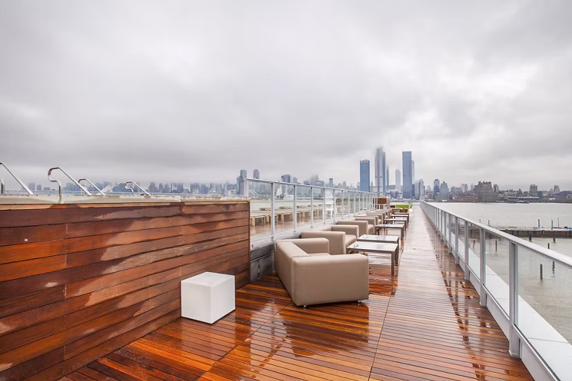 Rooftop deck with seating and city skyline views on a cloudy day at Harbor 1500 Apartments