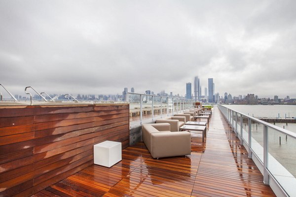 Rooftop deck with seating and city skyline views on a cloudy day at Harbor 1500 Apartments