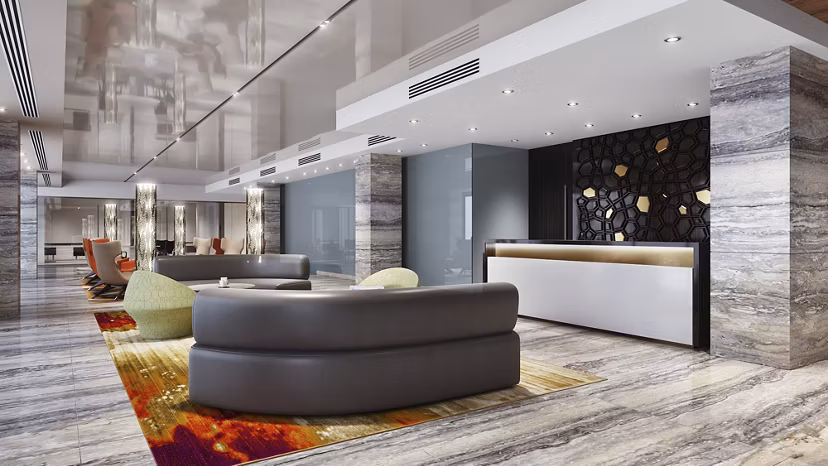 Stylish lobby with curved seating, reception desk, and marble floors at Harbor 1500 Apartments in Weehawken
