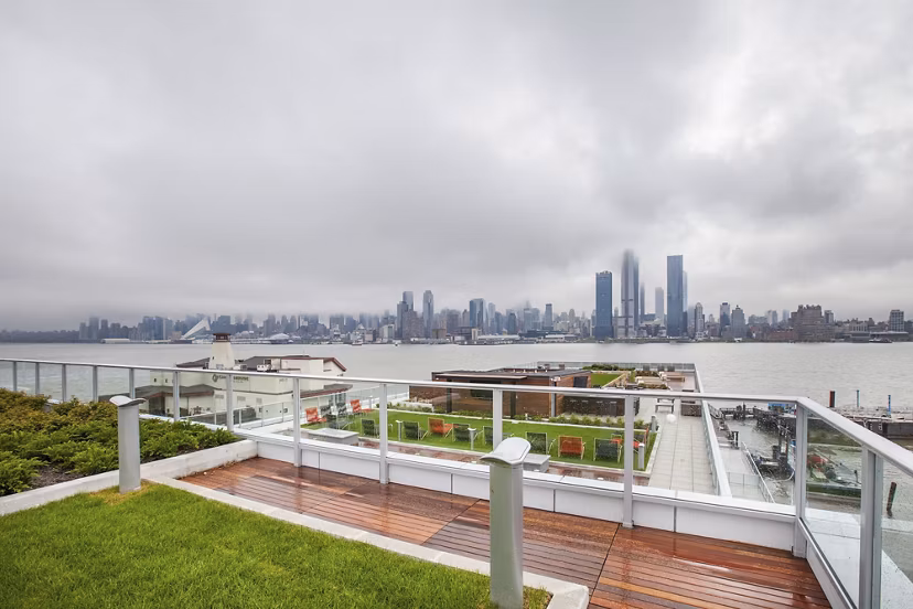 Rooftop terrace offering stunning city skyline and river views on a cloudy day at Harbor 1500 Apartments