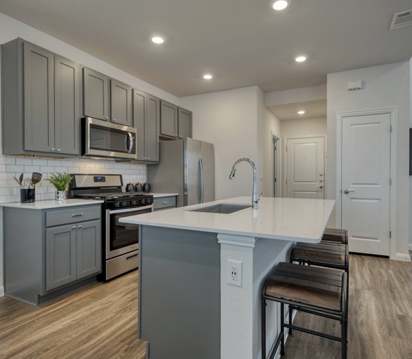 Modern kitchen with sleek countertops and stainless steel appliances at Pradera Luxury Rental Homes