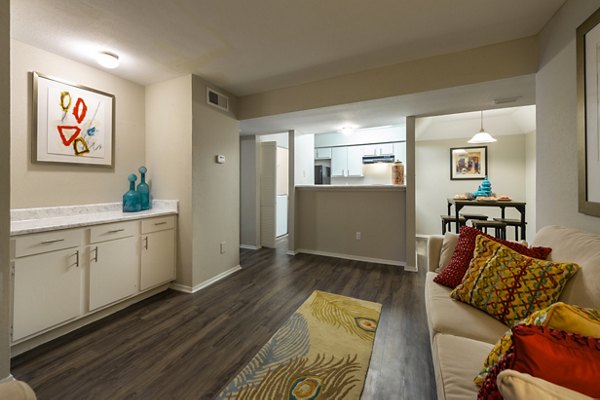 Living room highlighting cozy seating and natural light at Raintree Apartments