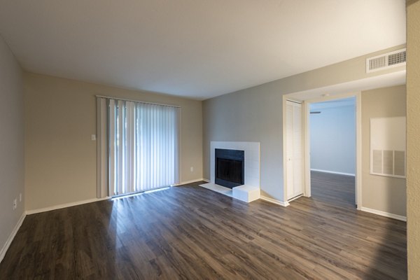 Living room featuring contemporary design and cozy seating in Raintree Apartments