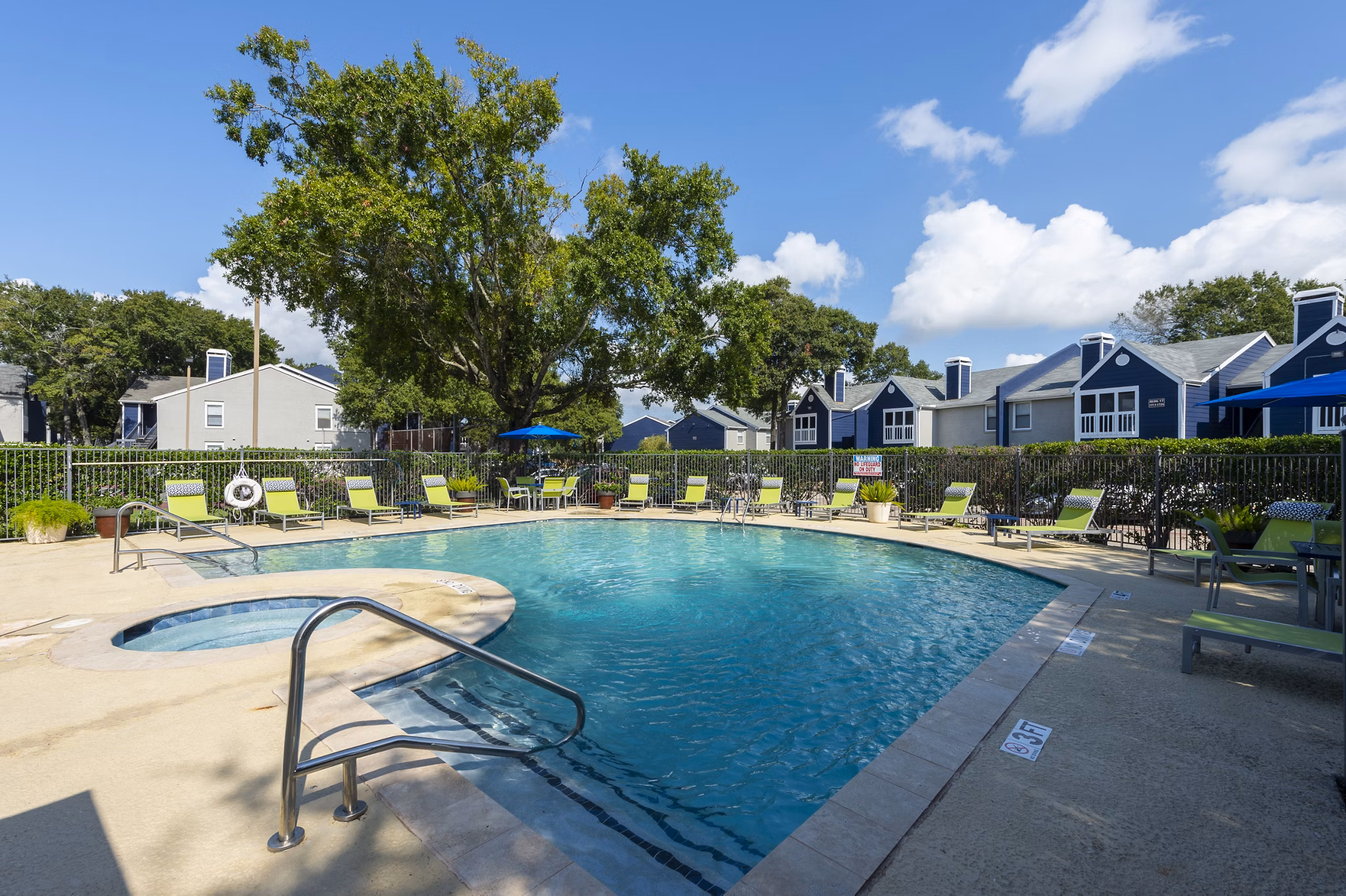 Pool with lush landscaping at Raintree Apartments Ideal for relaxation and leisure in a serene setting