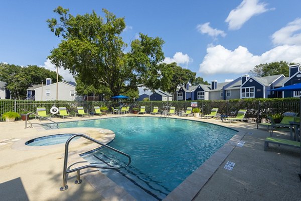 Pool with lush landscaping at Raintree Apartments Ideal for relaxation and leisure in a serene setting