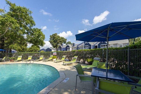 Resort-style pool with lounge chairs at Raintree Apartments, a luxury community offering premium amenities and tranquil settings