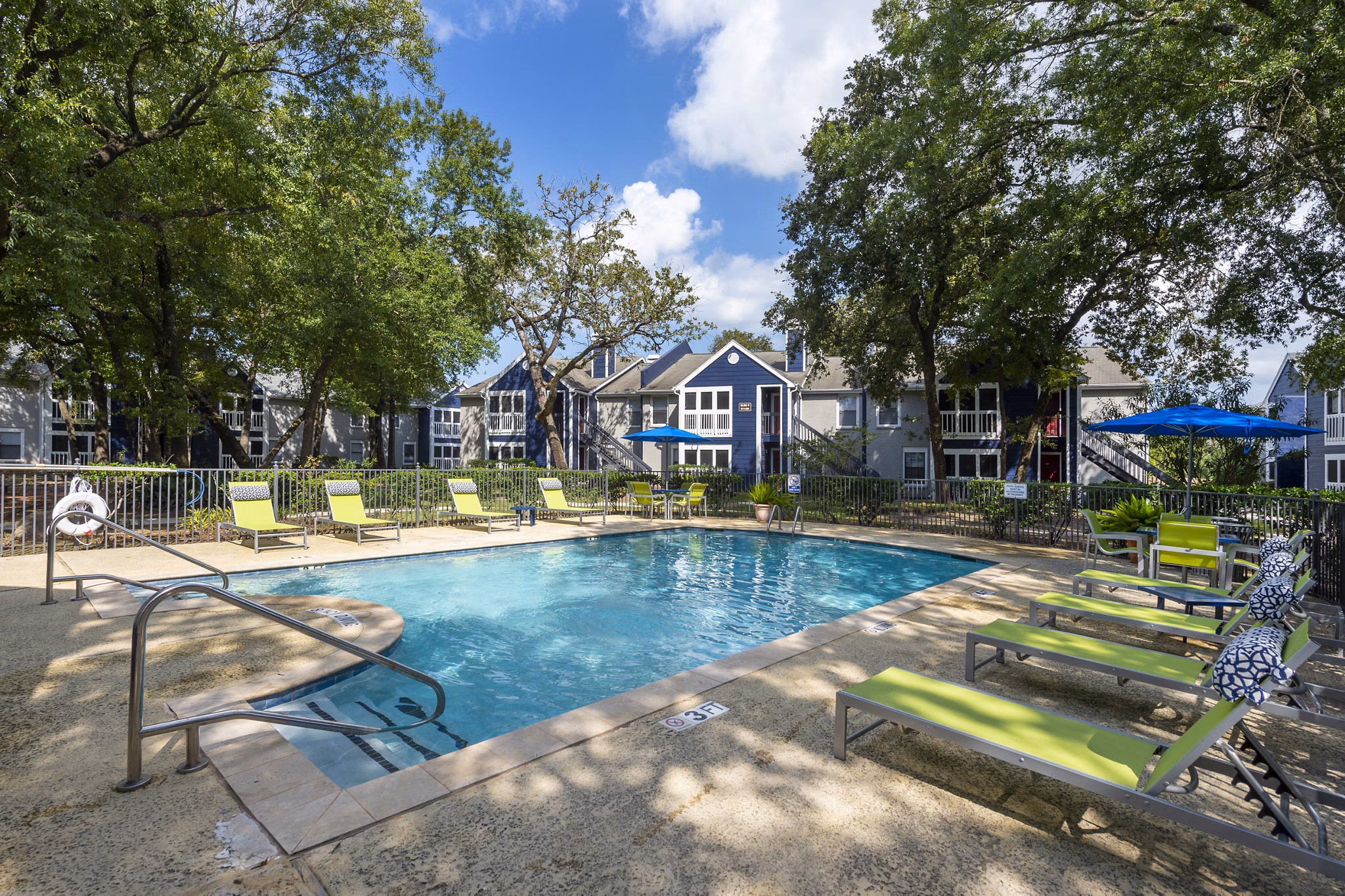 Spacious outdoor pool area at Raintree Apartments offering luxurious relaxation