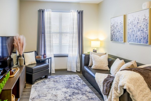 Spacious living room with modern furnishings at College View Apartments, featuring stylish decor and ample natural light