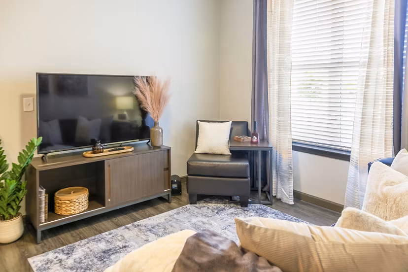 Spacious modern living room with stylish furniture and large windows at College View Apartments, offering comfortable luxury apartment living