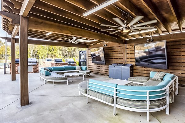 Outdoor grilling and patio area at College View Apartments featuring modern seating and lush landscaping
