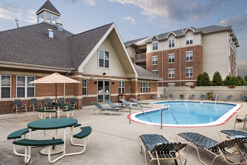 Outdoor pool with sun loungers at Evergreen Commons Apartments, perfect for relaxation and leisure in a luxurious setting