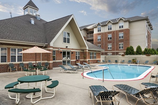 Outdoor pool with sun loungers at Evergreen Commons Apartments, perfect for relaxation and leisure in a luxurious setting
