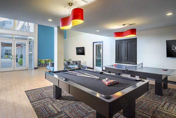 Game room with pool table and lounge seating at The Local Downtown Apartments, ideal for socializing and relaxation in urban luxury living