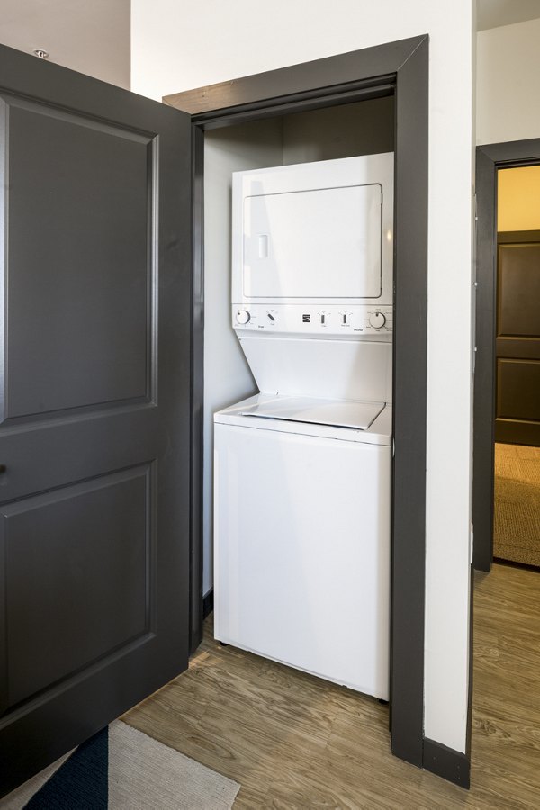 Laundry room featuring modern appliances at The Local Downtown Apartments