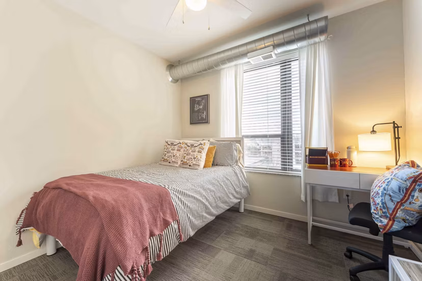 Modern bedroom with sleek furniture and large window at The Marshall Apartments
