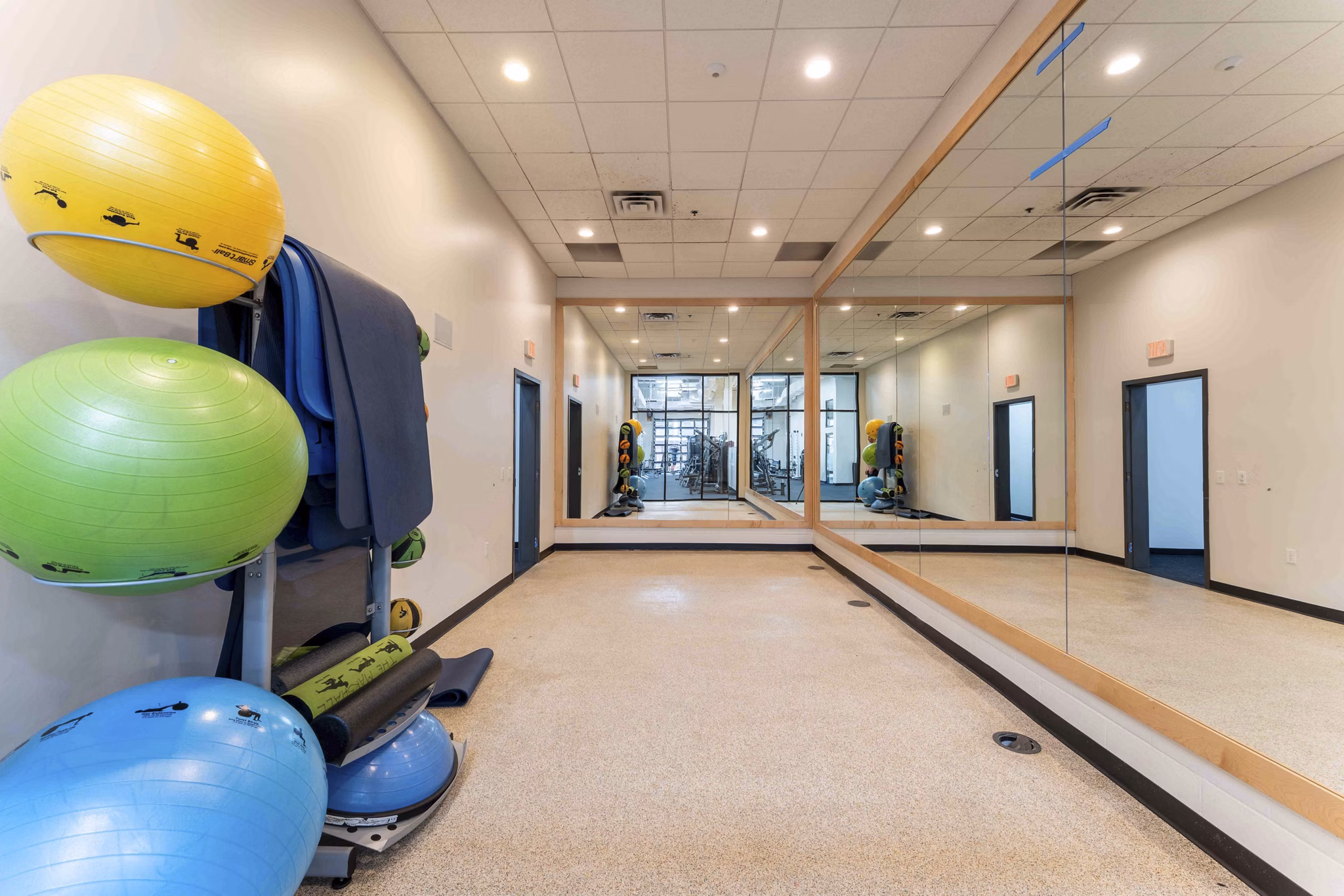 Yoga and spin studio with mirrored walls and exercise bikes at The Marshall Apartments luxury complex