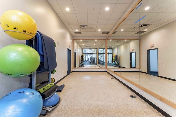 Yoga and spin studio with mirrored walls and exercise bikes at The Marshall Apartments luxury complex