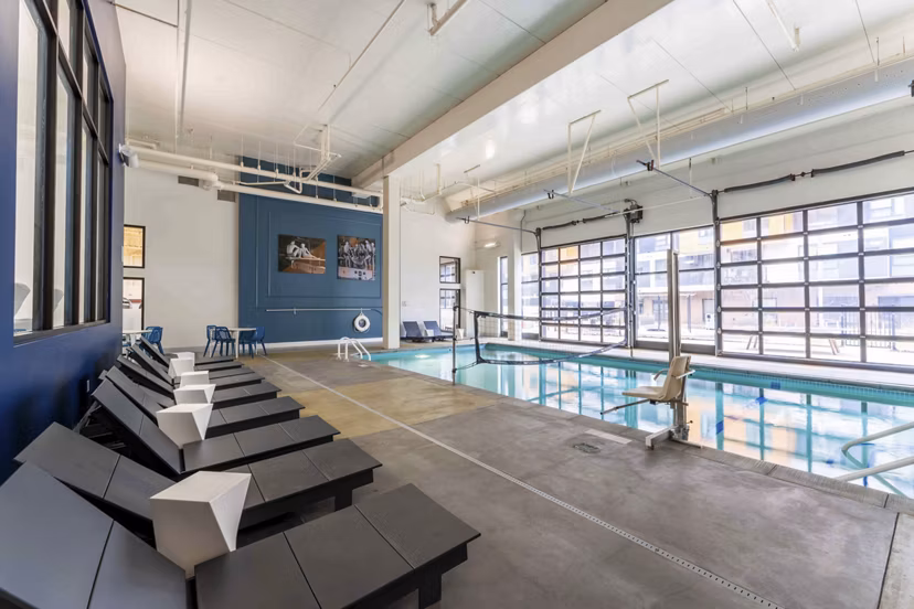 Elegant indoor pool with lounge chairs at Bay Court at Harbour Pointe Apartments, ideal for relaxation and fitness activities