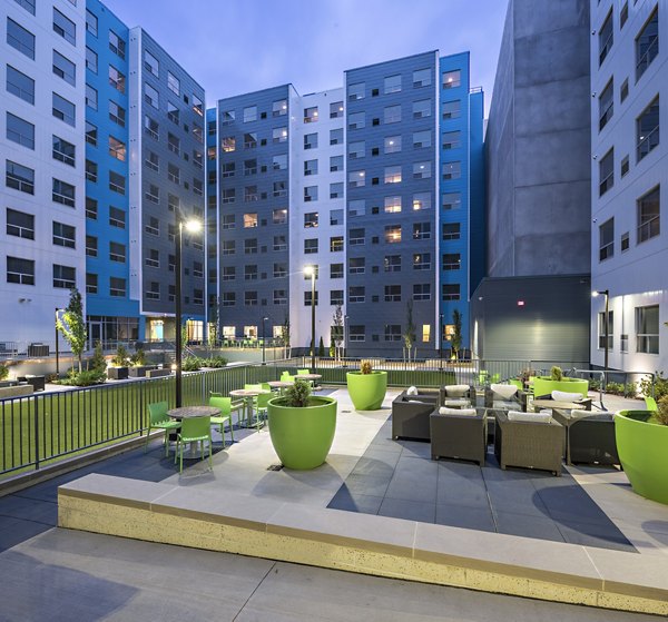 Spacious patio with stylish seating at SkyVue Apartments, offering panoramic city views from luxury high-rise residences