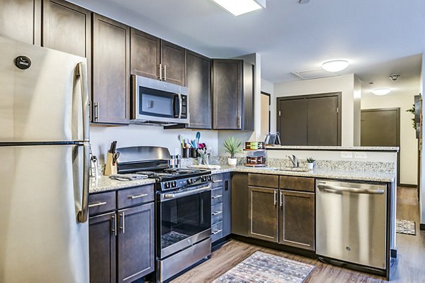 Spacious kitchen with modern appliances and sleek cabinetry in Southside Commons Apartments, a Greystar luxury property