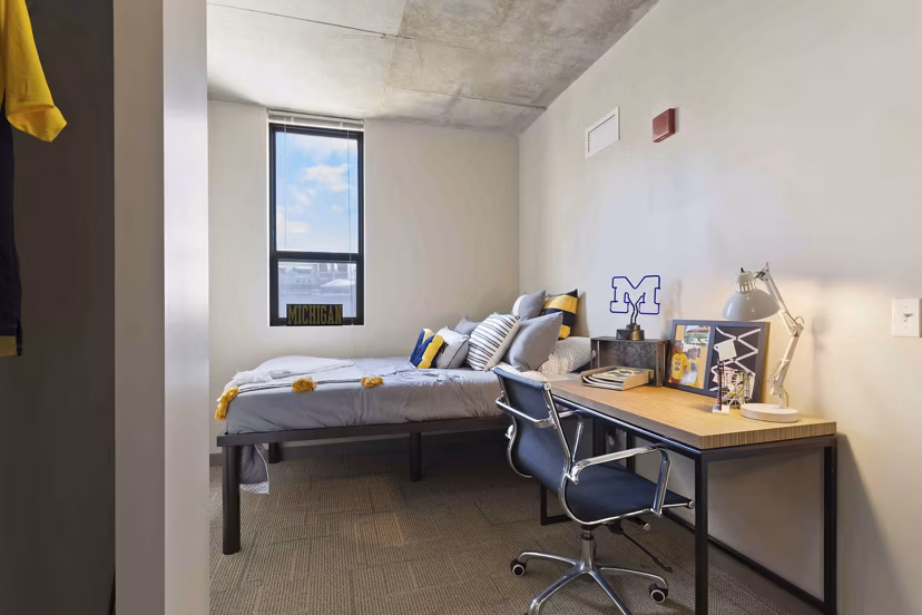 Modern bedroom featuring stylish dÃ©cor and large window in The Varsity Apartments