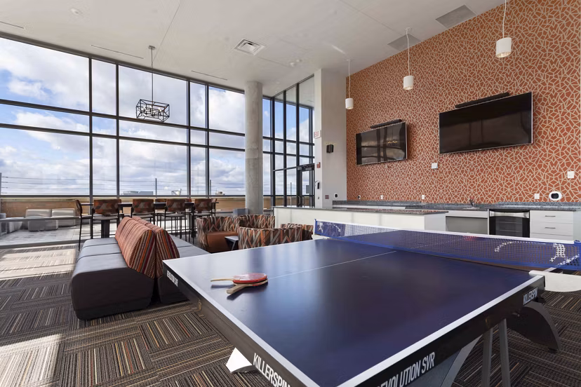 Game room with pool table and lounge area at The Varsity Apartments, luxury student housing near campus, designed for entertainment and relaxation