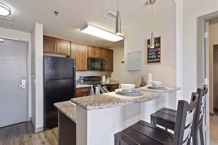 Modern kitchen with stainless steel appliances in The Varsity Apartments