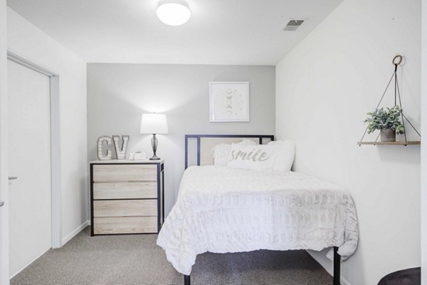 Spacious bedroom with modern furnishings at Campus Village, E Lansing apartments