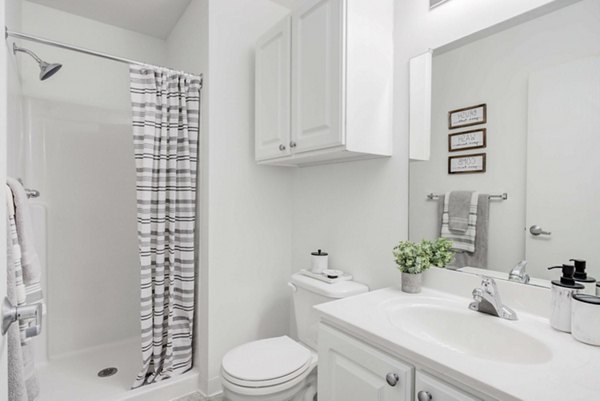 Modern bathroom with glass shower at Campus Village, East Lansing