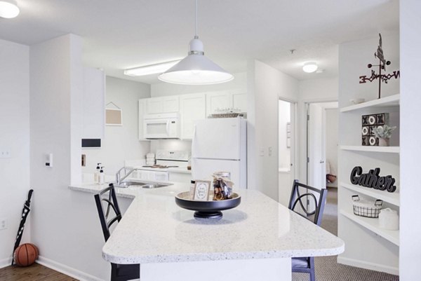 Modern kitchen with stainless steel appliances in Campus Village luxury apartments, East Lansing