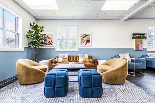 Clubhouse with modern lounge seating at University Village Apartments On Colvin, ideal for social gatherings and relaxation