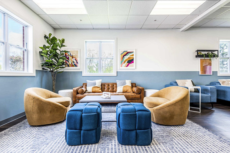 Clubhouse with modern lounge seating at University Village Apartments On Colvin, ideal for social gatherings and relaxation