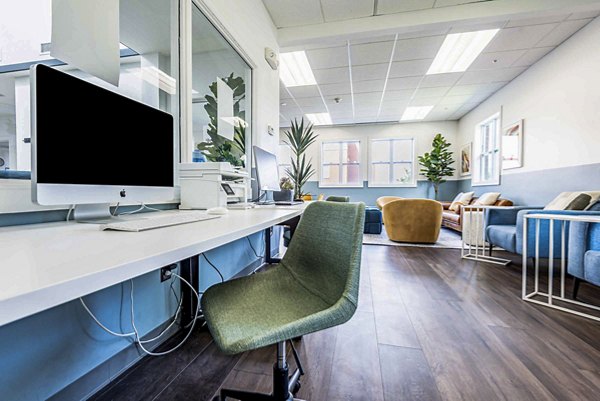 Clubhouse business center with modern workstations at University Village Apartments On Colvin, offering a productive environment for luxury living