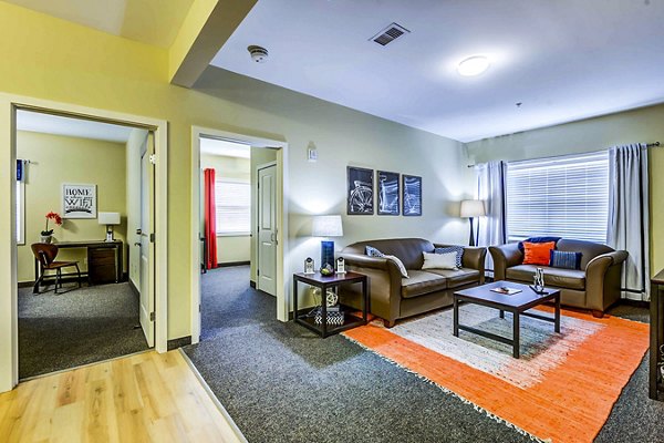 Spacious living room with modern furnishings in University Village on Colvin Apartments