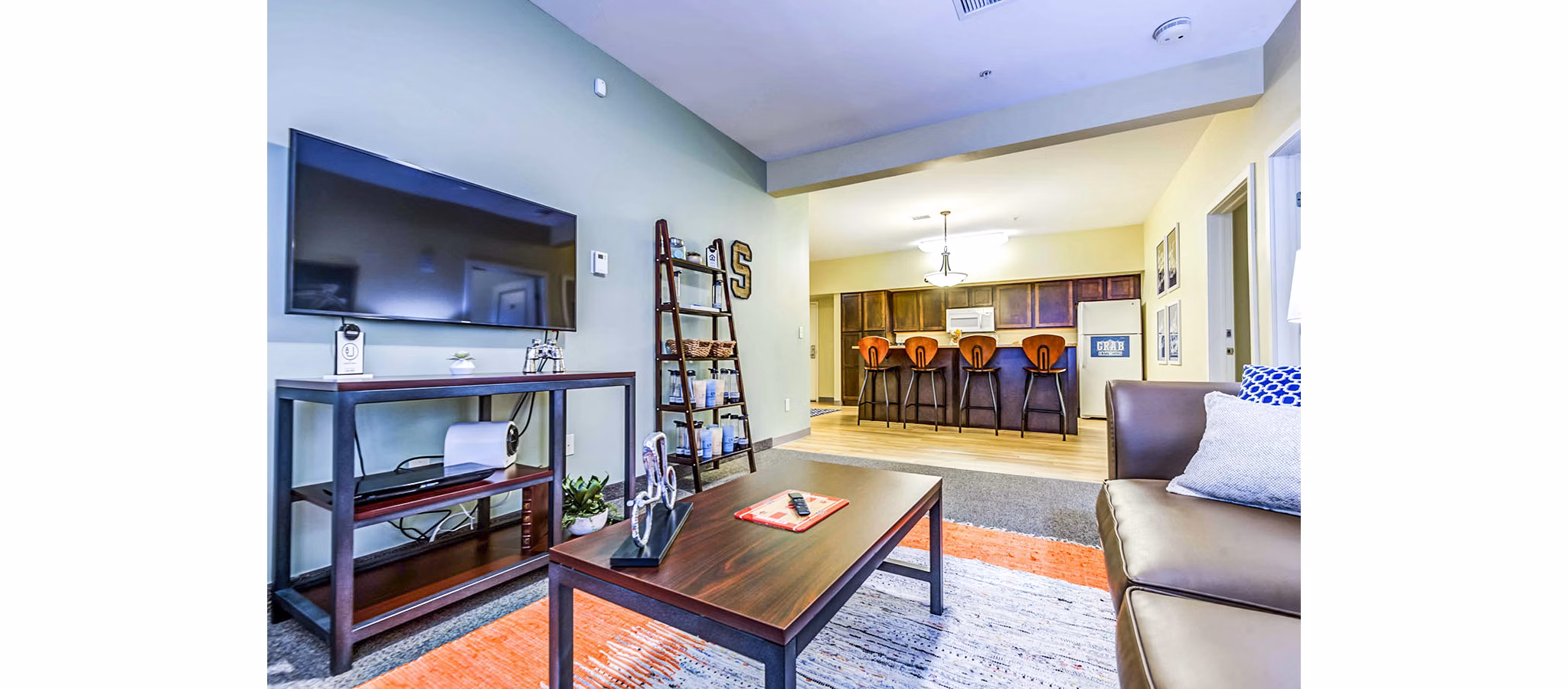 Living room with modern decor and natural light at University Village Apartments On Colvin