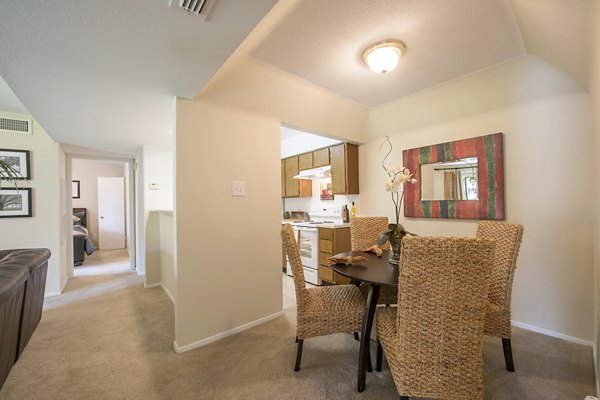 Dining area with elegant lighting and modern furniture at Huntcliff Apartments, showcasing luxury living in a welcoming atmosphere