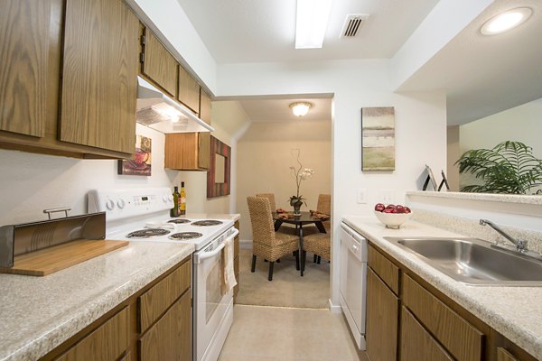 Modern kitchen with stainless steel appliances and marble countertops in Huntcliff Apartments