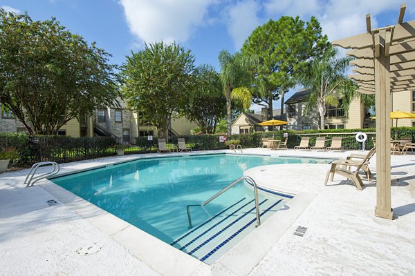 Serene outdoor pool area with sun loungers at Huntcliff Apartments