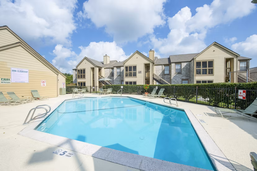 Luxurious outdoor pool at Huntcliff Apartments featuring lounge chairs and scenic views