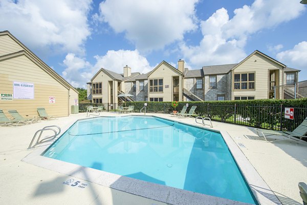 Luxurious outdoor pool at Huntcliff Apartments featuring lounge chairs and scenic views