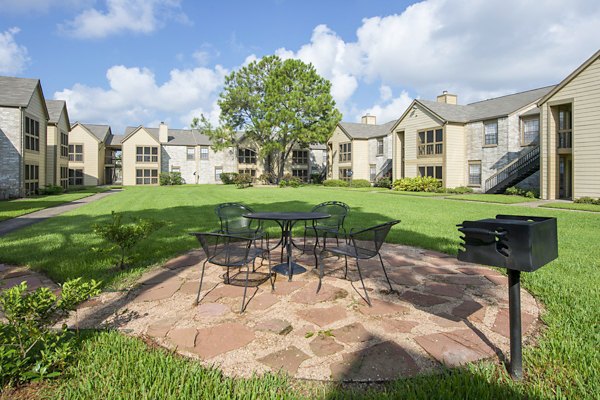 Outdoor grill area with seating at Huntcliff Apartments perfect for gatherings and BBQs