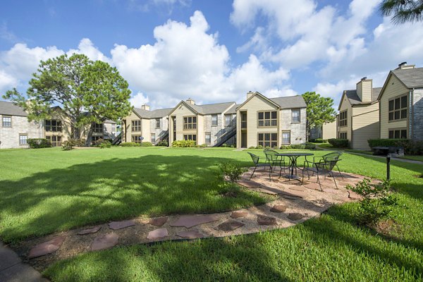 Outdoor grill area with modern seating at Huntcliff Apartments, perfect for social gatherings and barbecues