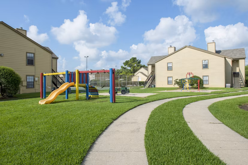 Playground at Huntcliff Apartments featuring modern play structures and picnic areas for residents' enjoyment