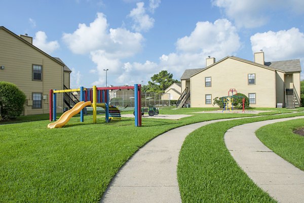 Playground at Huntcliff Apartments featuring modern play structures and picnic areas for residents' enjoyment