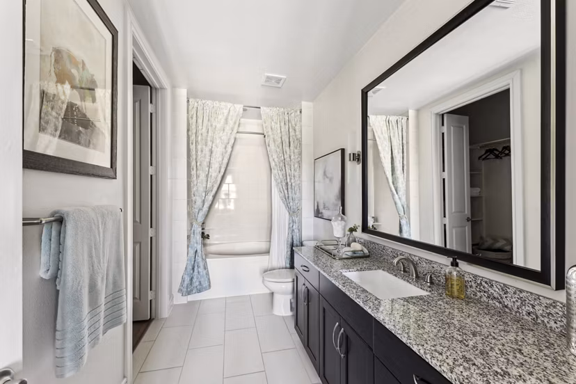 Luxurious bathroom with marble countertops and glass shower at The Michael at Presidio Apartments