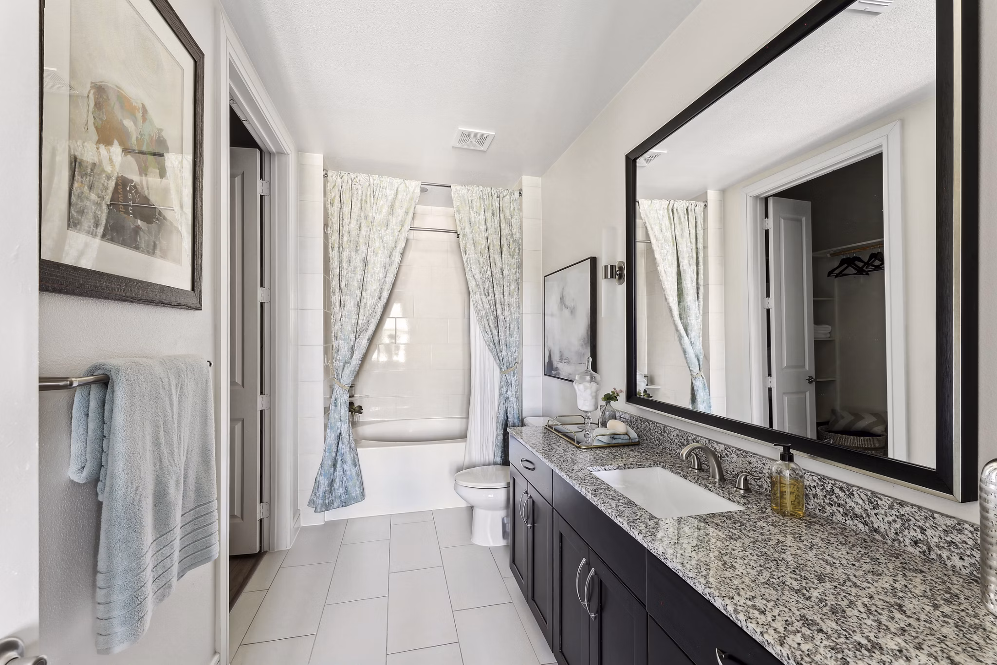 Luxurious bathroom with marble countertops and glass shower at The Michael at Presidio Apartments