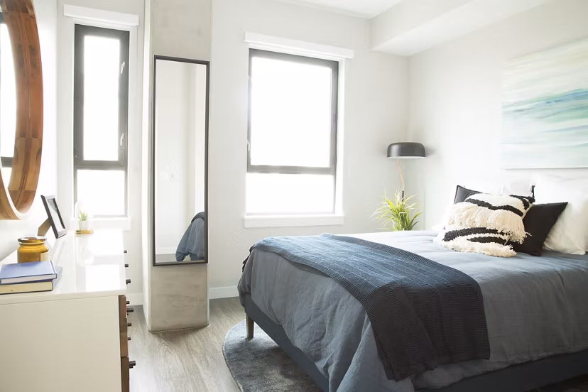 Cozy bedroom with plush bedding at Pierside South luxury apartments
