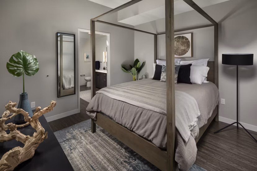 Spacious bedroom featuring modern decor and large windows at Pierside South Apartments, offering luxury living by the waterfront